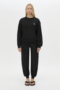 Front styled view CAMILLA AND MARC Bonnie relaxed logo track pant in black with elasticated drawcord waistband.