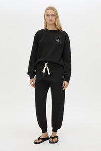 Front view CAMILLA AND MARC Bonnie relaxed logo track pant in black with elasticated drawcord waistband.