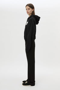 Side view CAMILLA AND MARC Carmont Graphic Hoodie in Black with boxy fit and black graphic logo.