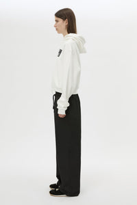 Side view CAMILLA AND MARC Carmont Graphic Hoodie in Soft White with boxy fit and black graphic logo.