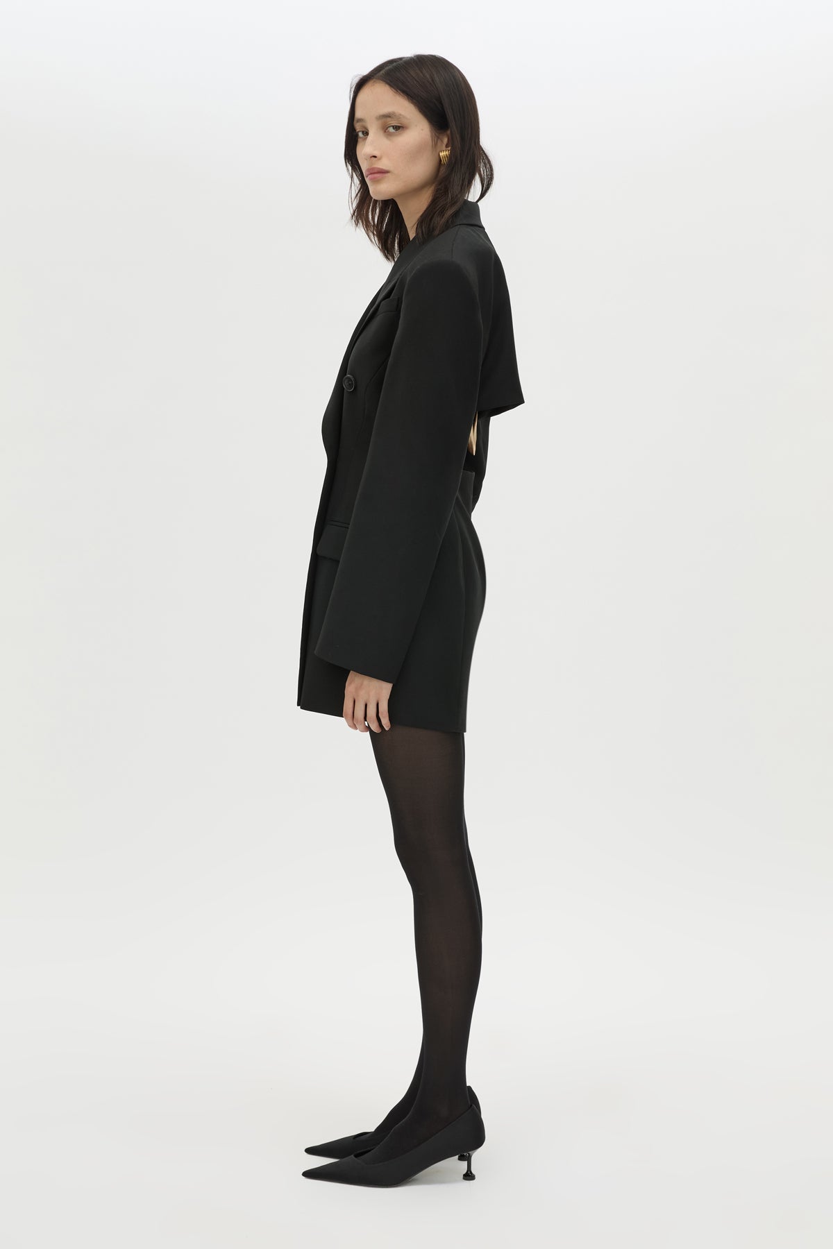 Side view CAMILLA AND MARC Cassie long sleeve mini dress in black with open back removable chain detail.