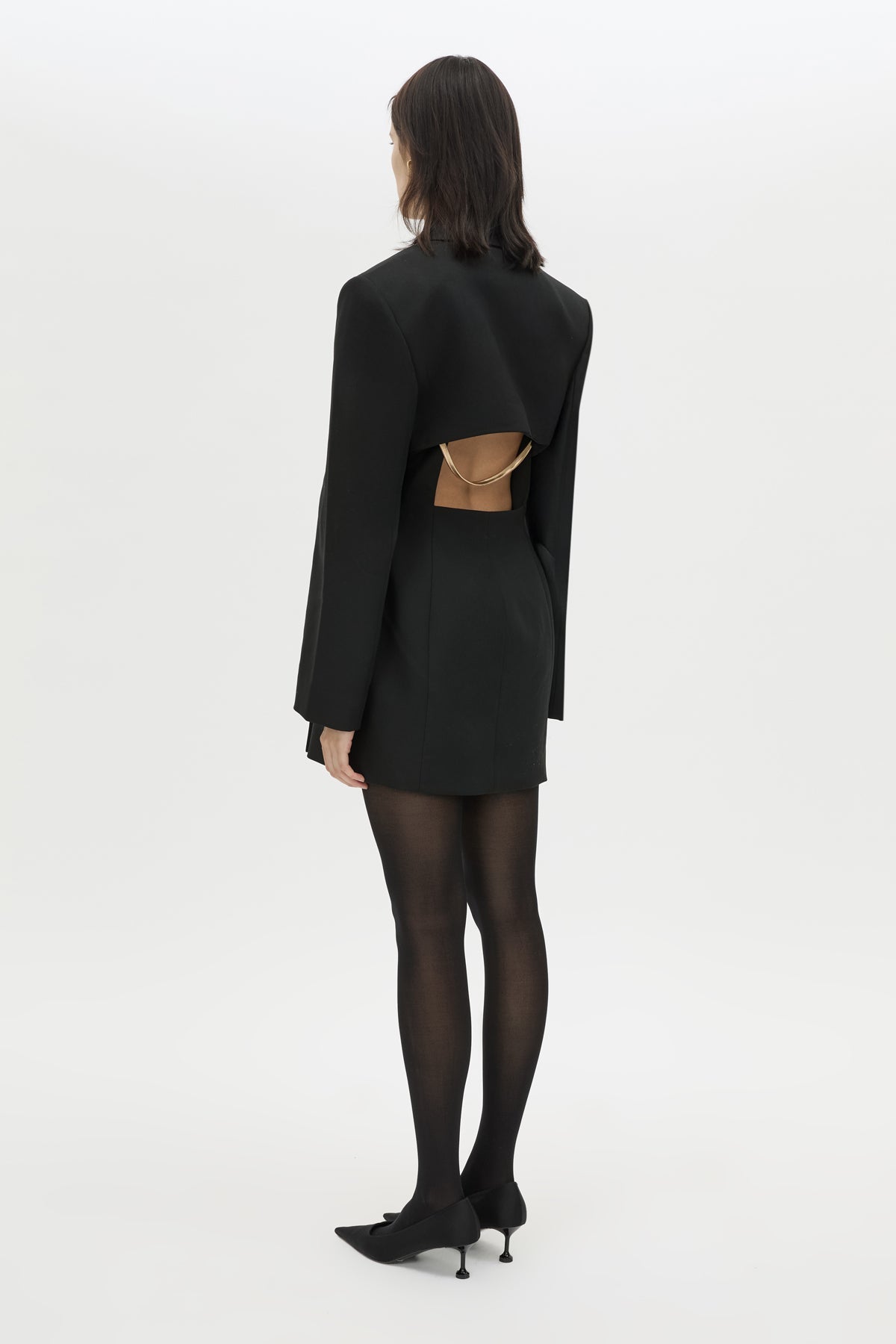 Back styled view CAMILLA AND MARC Cassie long sleeve mini dress in black with open back removable chain detail.