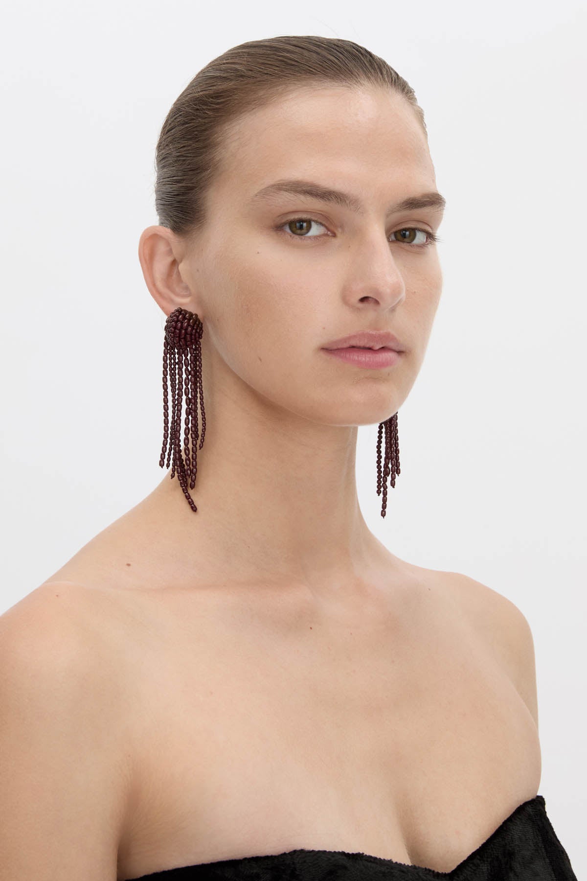 Side view CAMILLA AND MARC Irida Drop Earrings in burgundy with glossy beaded drop design.