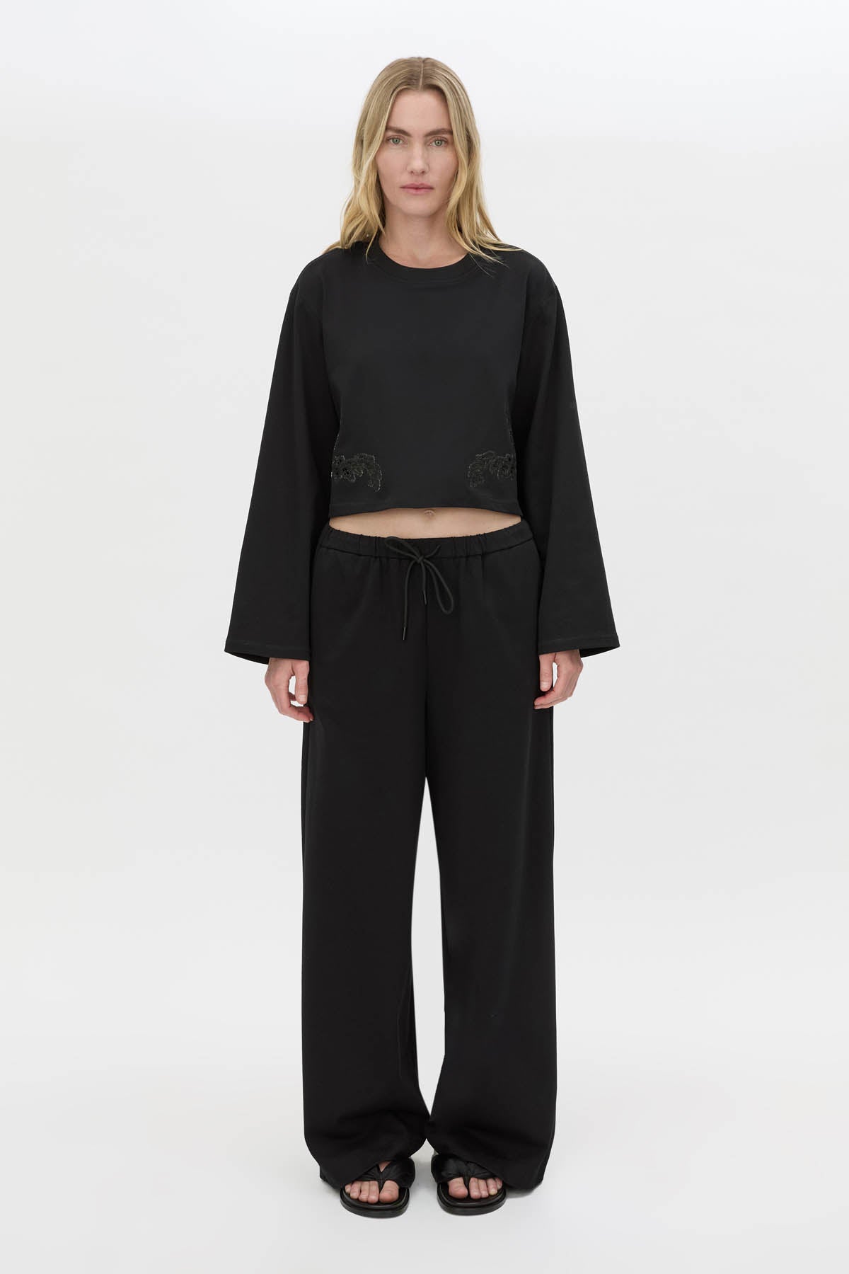 Front view CAMILLA AND MARC Niami Crochet Cropped Top in black with cut‑away crochet detailing at hem.