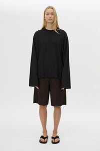 Front view with shorts CAMILLA AND MARC Peretti Long Sleeve Tee in Black with wide shaped sleeves.  