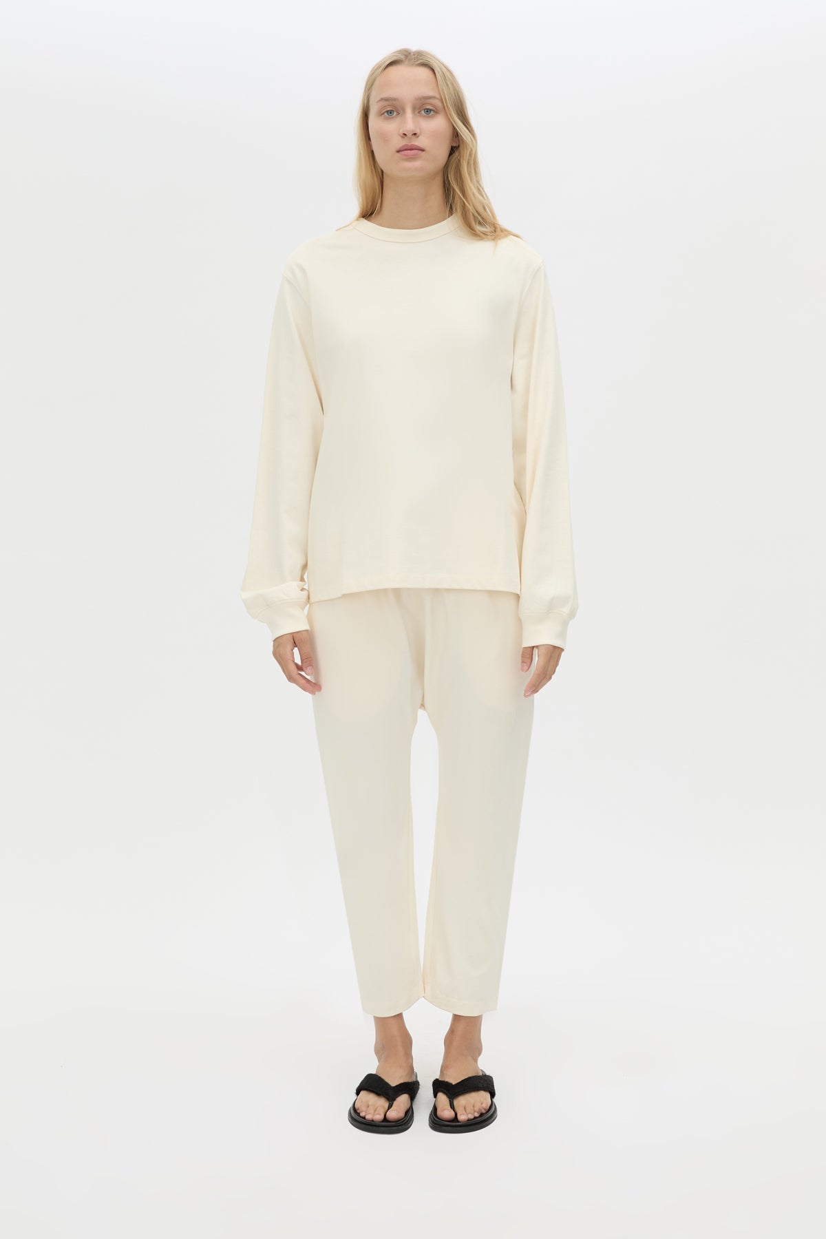 Front styled view CAMILLA AND MARC Studio cropped mid-rise track pant in winter white with elasticated waistband. 