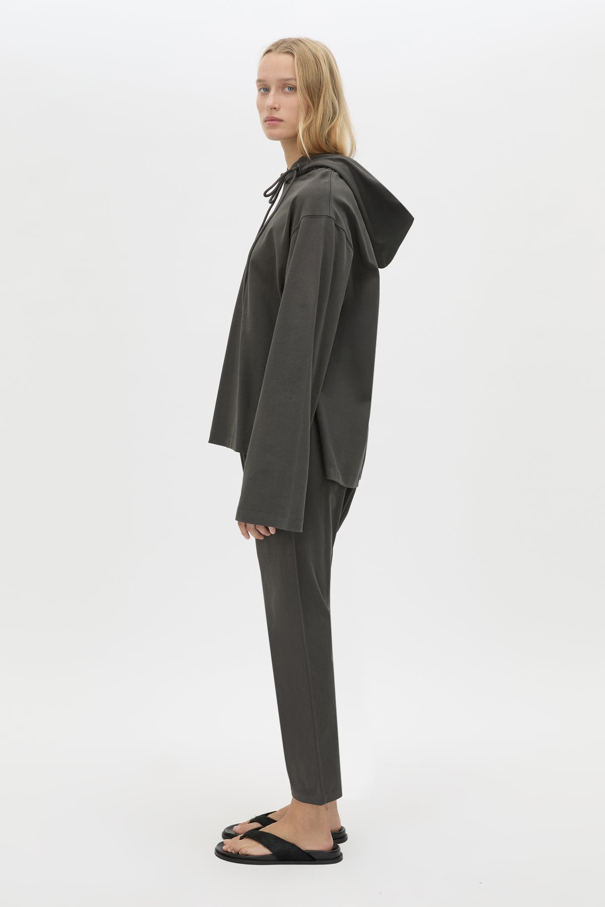 Side view CAMILLA AND MARC Studio Hoodie in Coal with relaxed long‑sleeve design and hooded silhouette.  