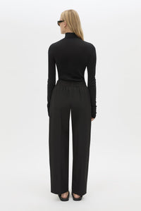 Back view CAMILLA AND MARC Sylvia soft suiting high-waisted pant in black with monogram patch at waistband.